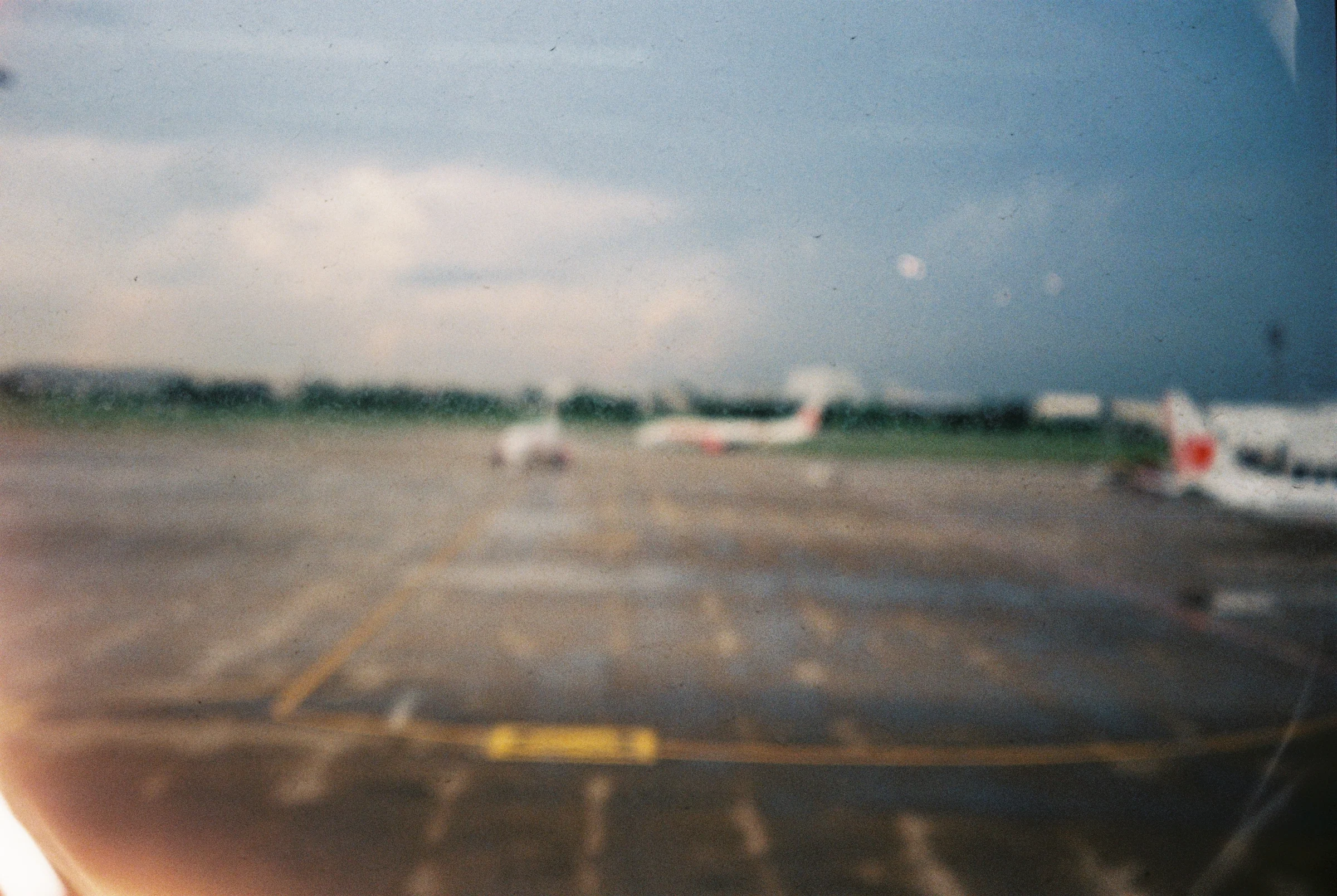 An airport runway seen through a soft, blurred film frame in Thailand.