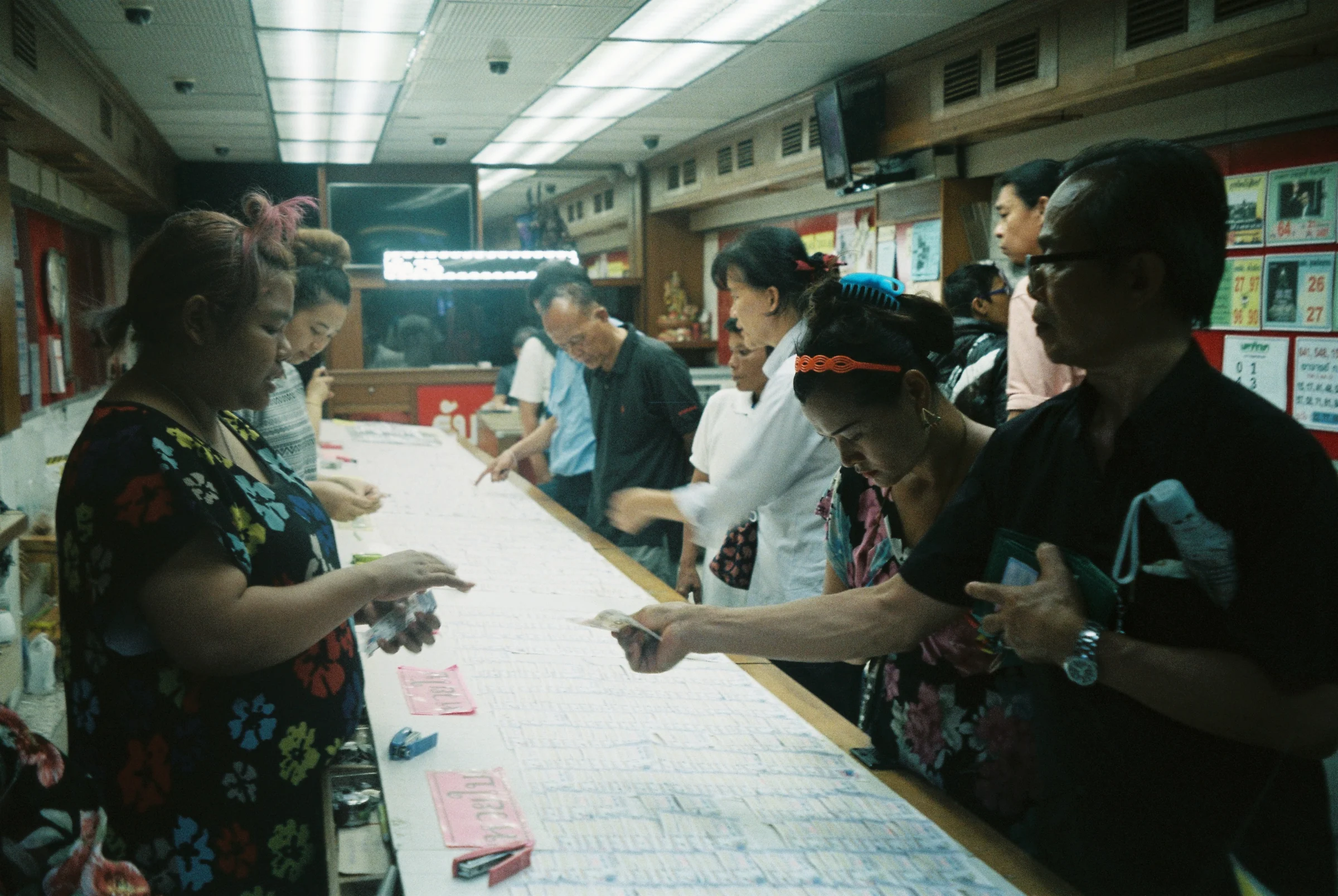 People talking across a food stall counter at night in Thailand.